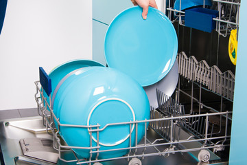 Woman empty out the dishwasher