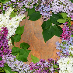 Branches lilac flowers. Floral frame on wood texture. Beautiful background