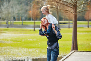 Mother holding daughter in shoulders in a lake