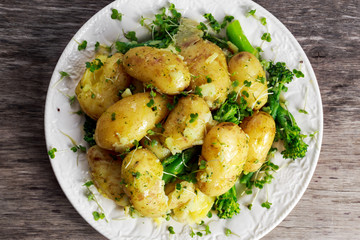 Young boiled potatoes with butter and vegetables.