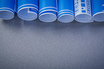 Stack of blue engineering drawings on grey background copy space