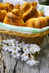 Fresh croissants in a wicker basket from bakery
