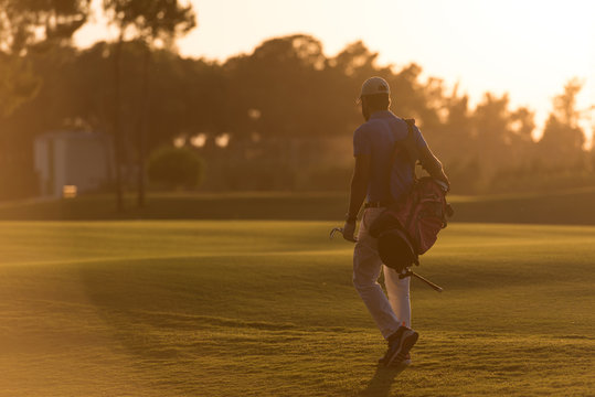 golfer  walking and carrying golf  bag at beautiful sunset