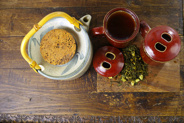 Japan's teapot and cups with green tea on wooden plank