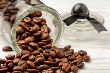 Coffee beans in glass jar on wooden background.