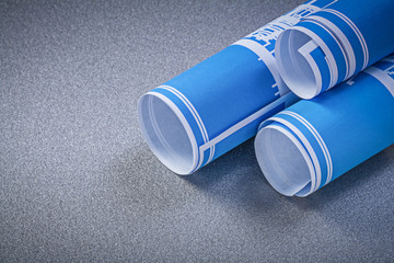 Blue rolled construction plans on grey background top view maint