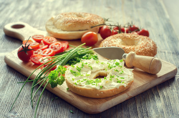 Bagels wtih cream cheese, tomatoes and chives for healthy snack