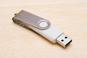 Blank USB thumb drive isolated on wooden board background