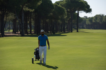 golf player walking with wheel bag