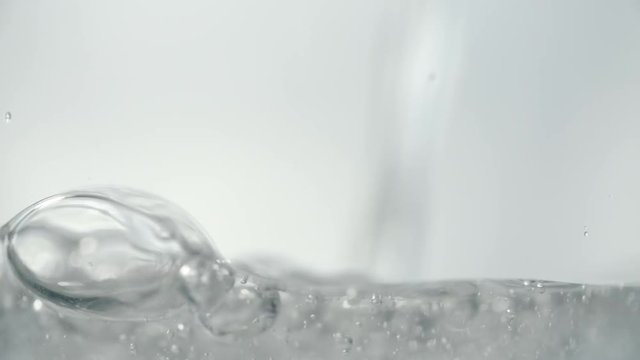 Pouring transparent soda water in a glass. Slow motion stock footage shot in 240 fps.