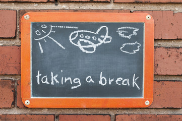 Tafel an einer Ziegelwand mit Text / Tafel an einer Ziegelwand mit Text taking a break.