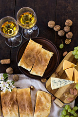 Fototapeta na wymiar Сheese pie, strudel with cheese, cheese pie 4. Wine, grapes, nuts, cheese, blue cheese, and coffee. dinner, lunch, romantic date, picnic, eating on nature.