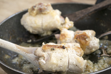turkey roll on a wooden spoon in a pan