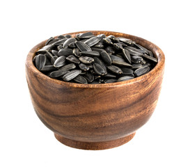 Sunflower seeds in wooden bowl, isolated on white background