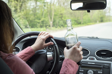 Woman drinking alcohol in the car.