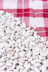 Raw white beans on the kitchen table cloth