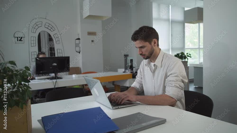 Poster worker using computer. businessman typing on laptop. young mixed race employee concentrated at the w