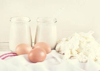 natural yoghurt in a glass jar, eggs and cheese. ingredients for baking