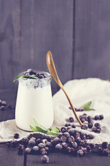 natural yoghurt with a black currant. Glass 0f yogurt with granola and black currants.