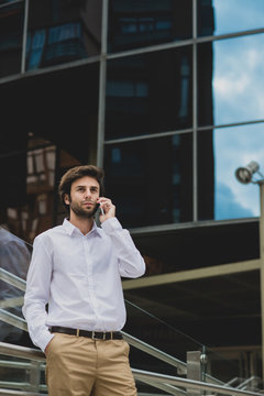 Handsome man talking over phone against of office building