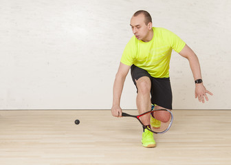 Young Caucasian man playing squash