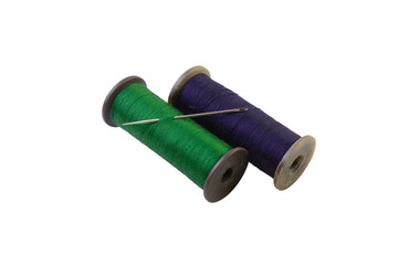 macro threads green and blue color on reels with an iron needle isolate on a white background