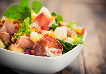 Salad with prosciutto, ham and melon 