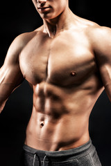 Close-up of a power fitness man on black background
