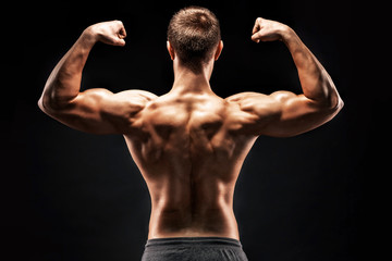 Fototapeta na wymiar Rear view of muscular young man showing back, biceps muscles