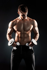 Fototapeta na wymiar Mighty fitness man showing his gread body with dumbbells