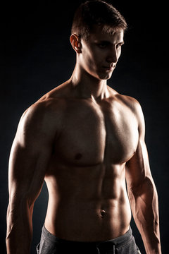 Mighty fitness man showing his gread body with dumbbells