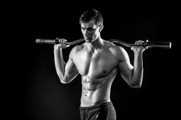 Strong man holding barbell on his shoulders,