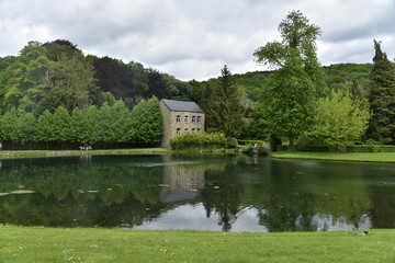 Fototapeta na wymiar L'étang du Moulin dans un paysage verdoyant aux Jardins d'Eau d'Annevoie