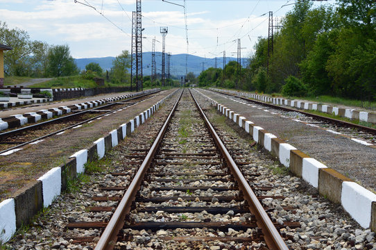 Reaching the horizon straight railways. Small railway station. Bulgarian countryside. 