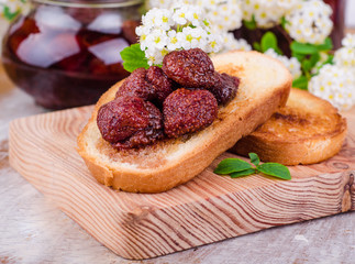Toast with strawberry jam on wooden board on wooden background. Selective focus