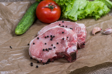 Sliced pieces of raw meat for barbecue with fresh Vegetables tomatoes, lettuce on wooden surface. 