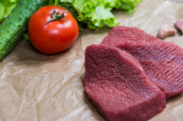 Raw meat barbecue with fresh vegetables wooden surface. Food, steak, beef bbq, tomatoes, peppers, spices for cooking. 