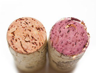 Two wine corks on a white background