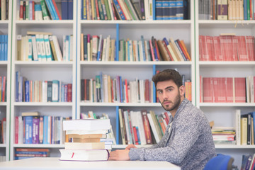 portrait of student while reading book  in school library