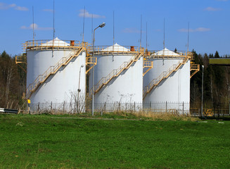 Fototapeta na wymiar Three white storage tanks at petrol station