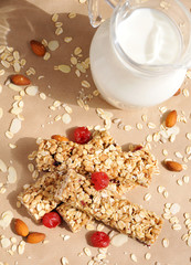 Organic granola bars with nuts and dry fruits and a jug with milk