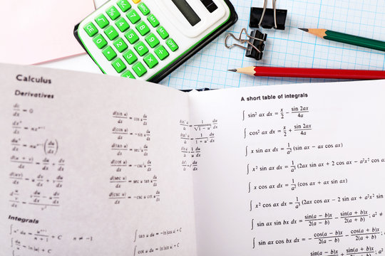 School supplies and textbook on mathematics close up