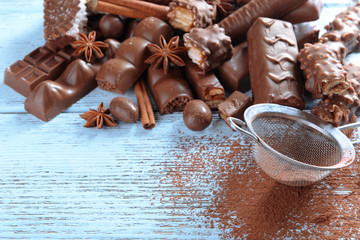 Chocolate sweets with powder on wooden background