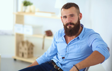 Fototapeta premium Young businessman sitting on chair in office