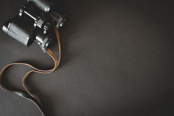 Old binoculars on black background
