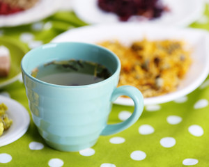 Cup of tea with aromatic dry tea on wooden background