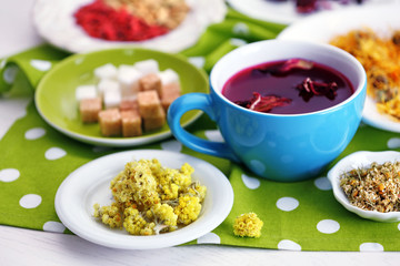Cup of tea with aromatic dry tea on wooden background
