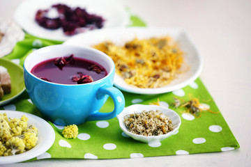 Cup of tea with aromatic dry tea on wooden background