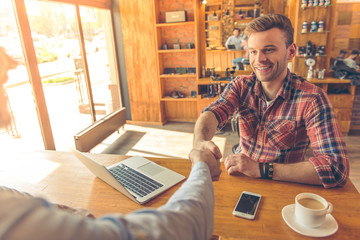 Young businessmen with gadget at cafe