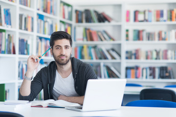 student in school library using laptop for research